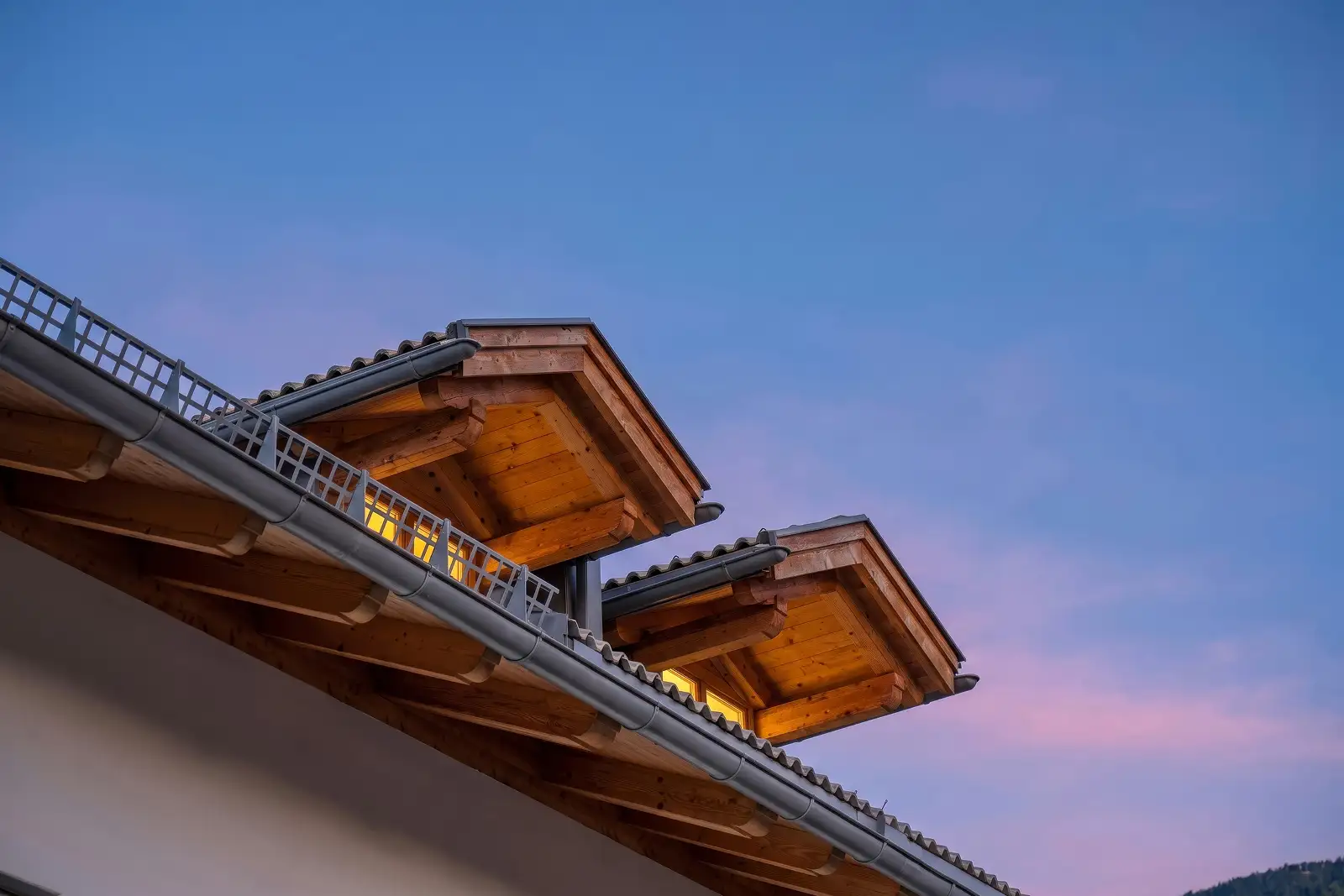 Due finestre in legno con tettoia inserite sul tetto di una casa ristrutturata a Varena