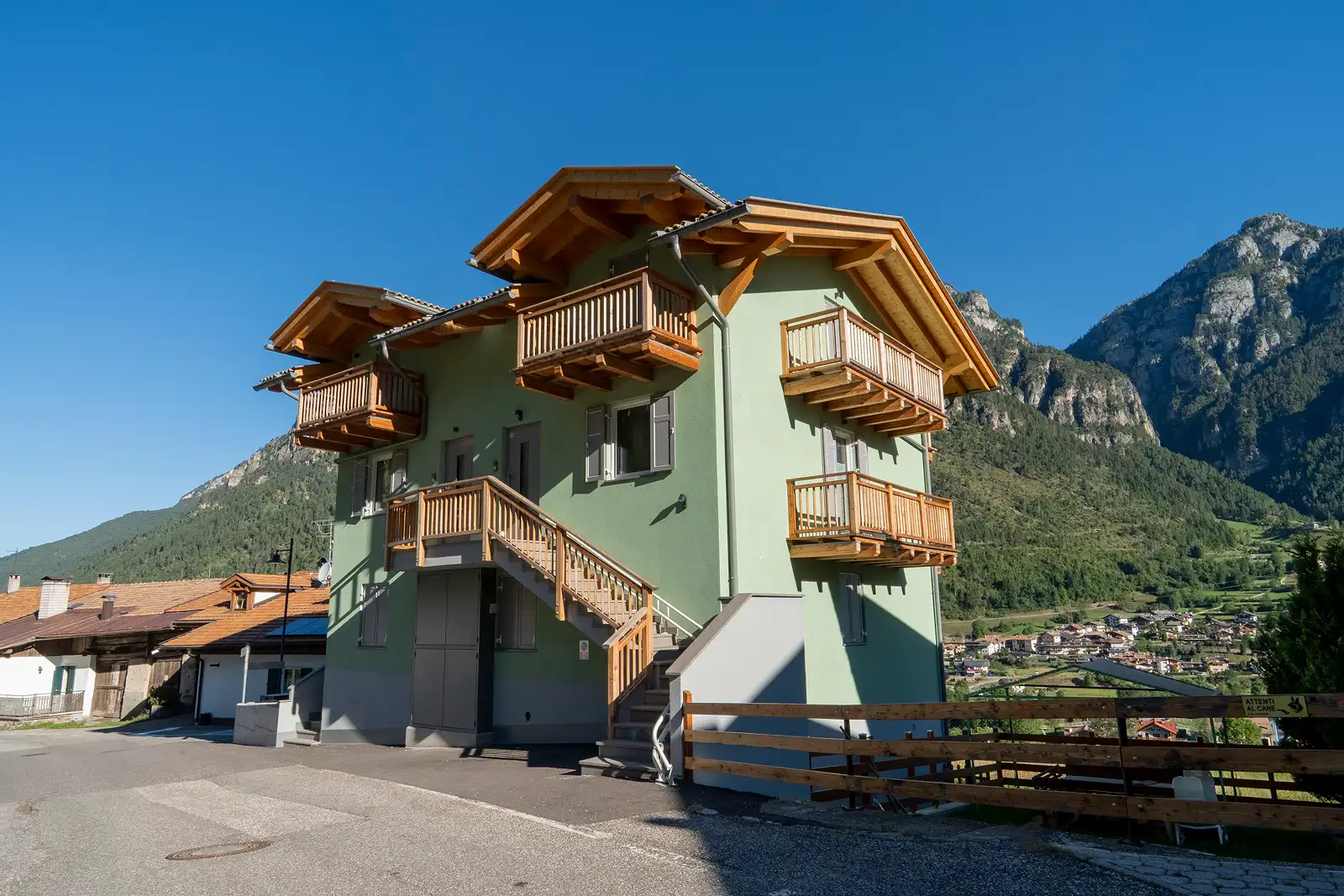 Riqualificazione di condominio alpino con rivestimenti e balconi in legno massiccio in Val di Fiemme